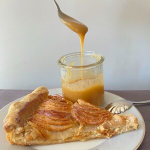 pot of salted caramel sauce with an apple tart