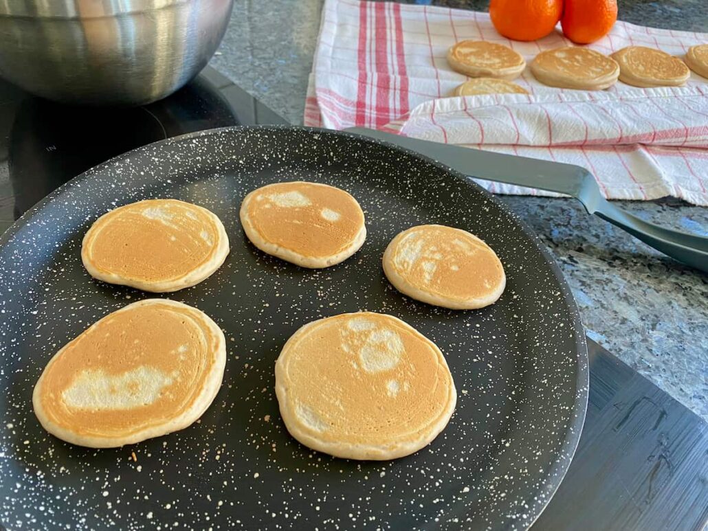 thick pancake rounds on a hot pan turning out on to a tea towel