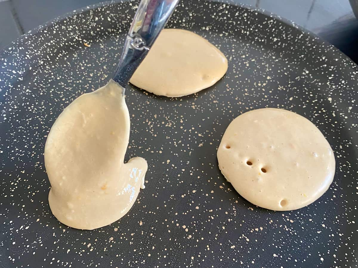 dropping thick batter on to a hot griddle