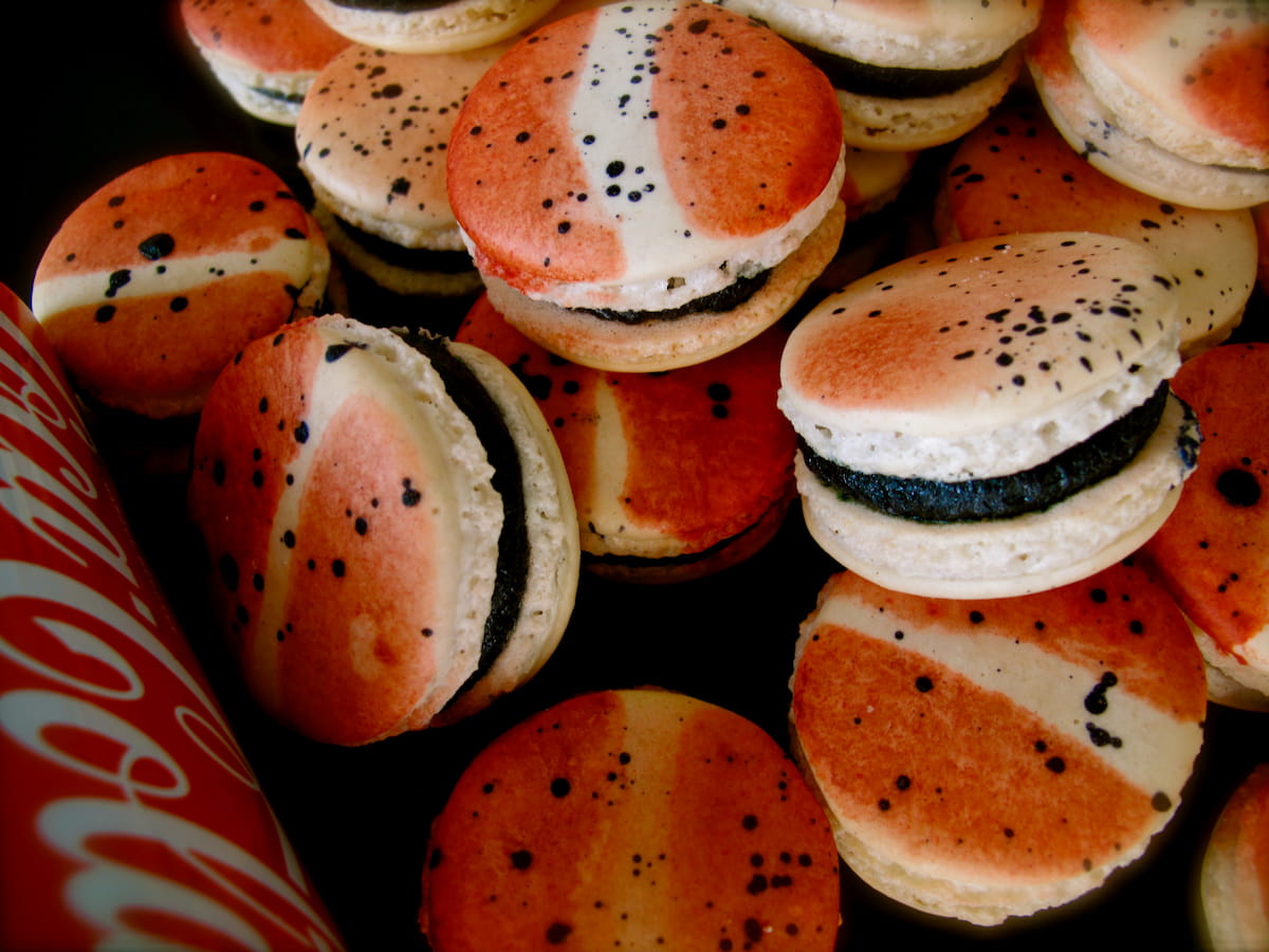 close-up of red white striped macarons with black coca cola filling