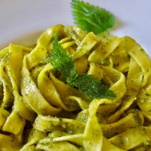 pasta noodles tossed in green nettle sauce and topped with fried nettles
