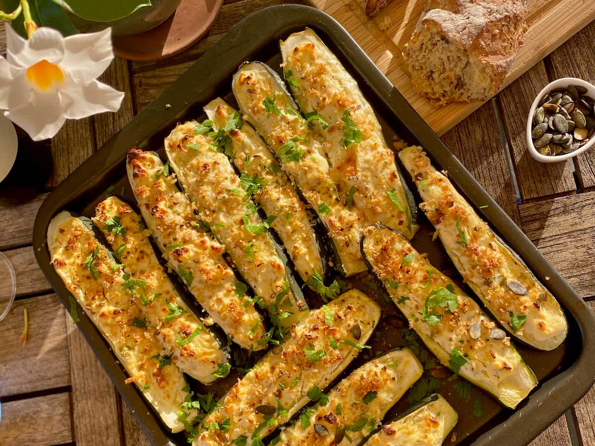 halved zucchini shells filled with cheese, breadcrumbs, nuts and herbs