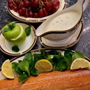 sauce boat of light creamy sauce next to a filled green apple, served with smoked salmon