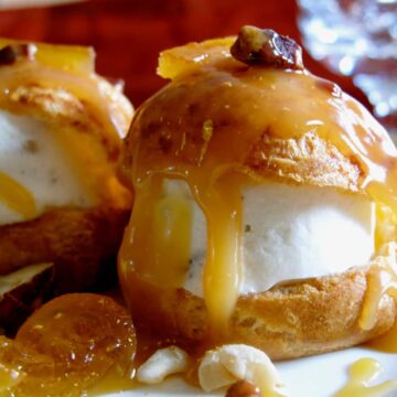 profiteroles filled with ice cream and drizzled with caramel sauce