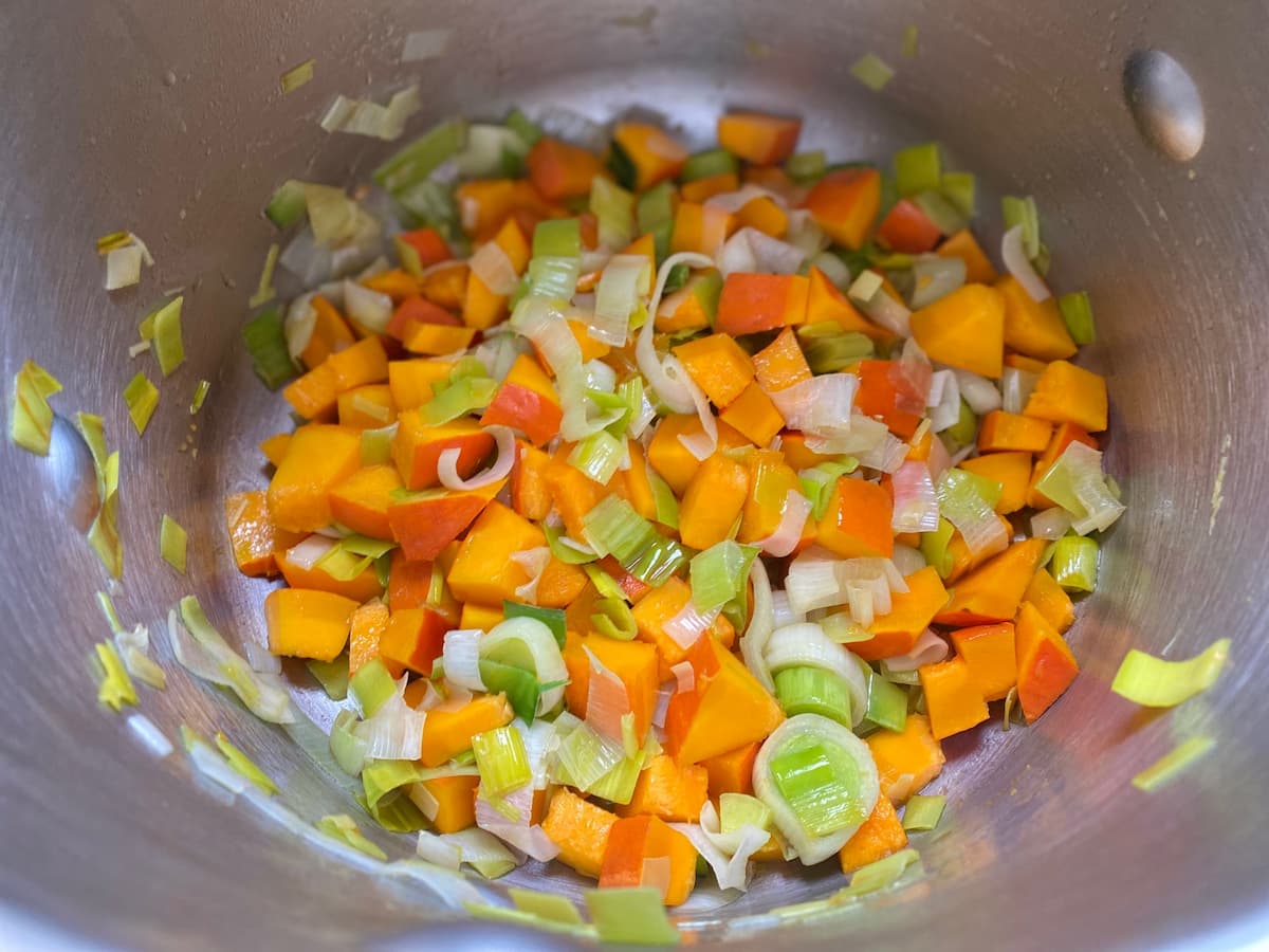 chopped pumpkin and leeks sweating in a pan