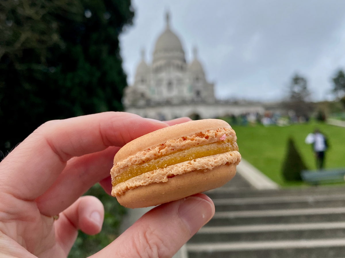 a perfect Parisian macaron with frilly feet in front of Sacré Coeur, Montmartre