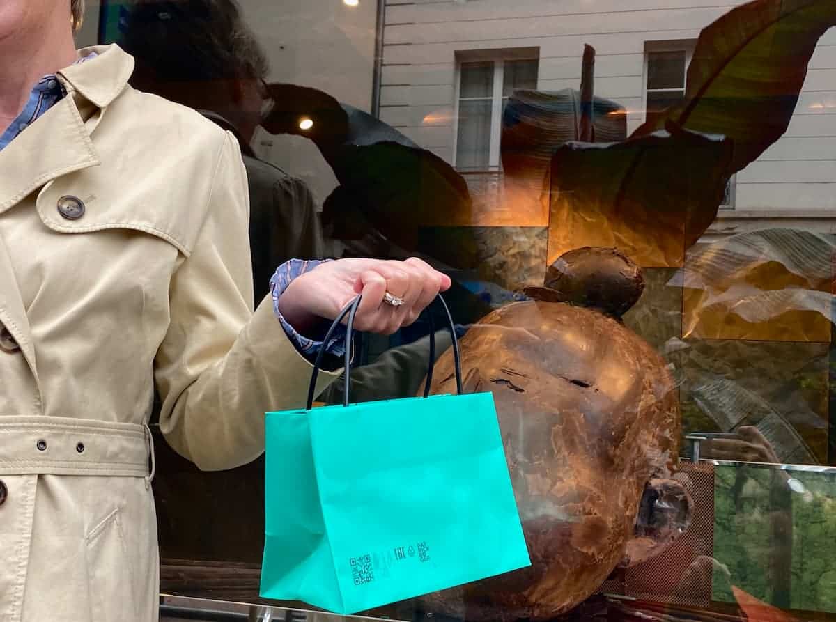 green bag in front of chocolate shop in paris