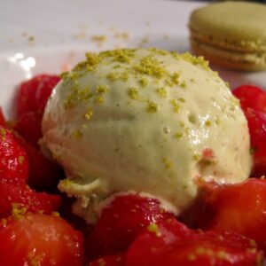 scoop of wasabi ice cream with strawberries and macaron