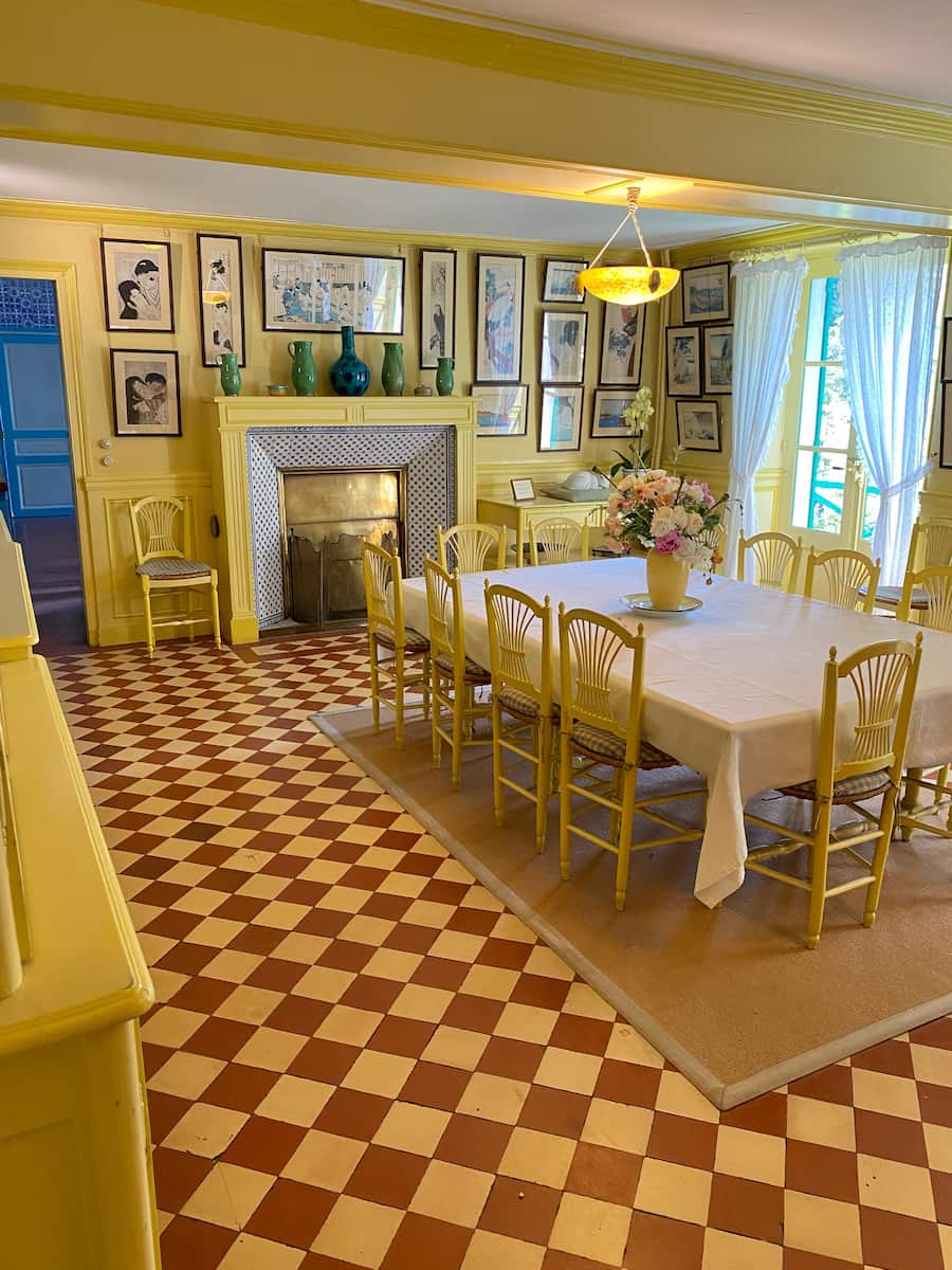 bright yellow dining room in France with a fireplace and long table