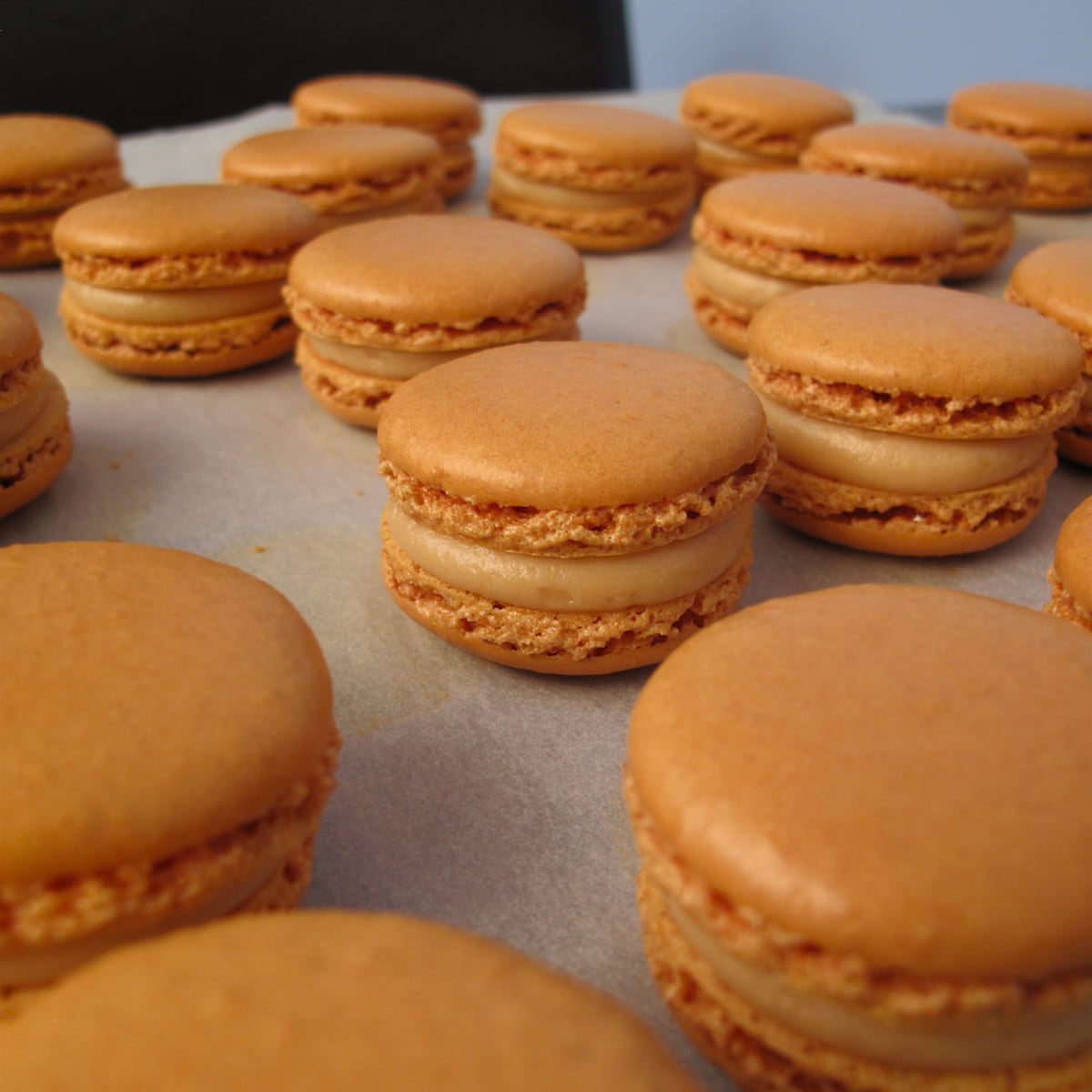 caramel macarons sitting on baking paper