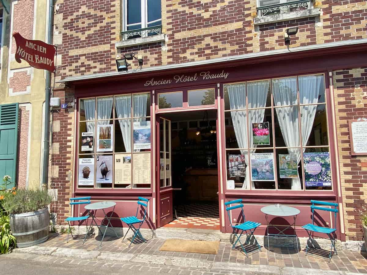 old brick restaurant of Hotel Baudy storefront with tables outside