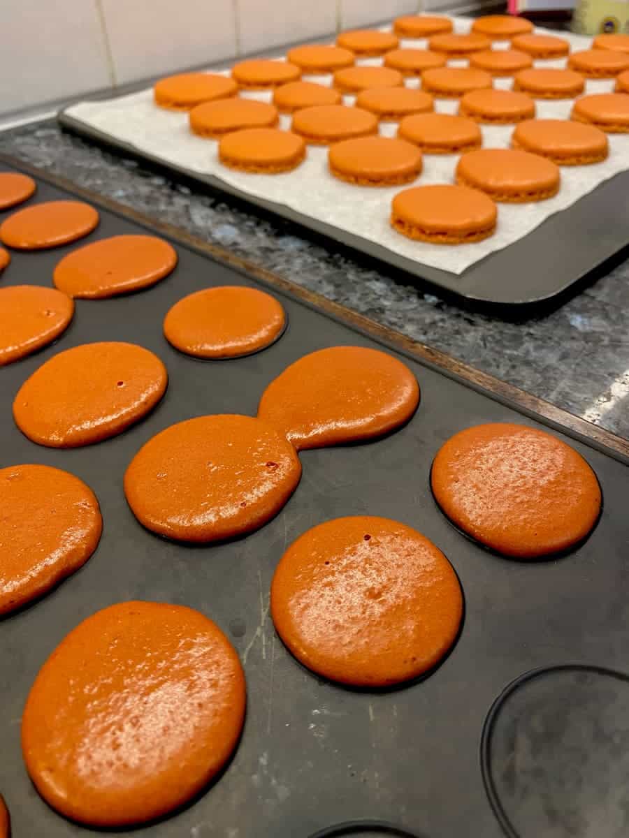 side by side silicone mat and baking macarons on parchment