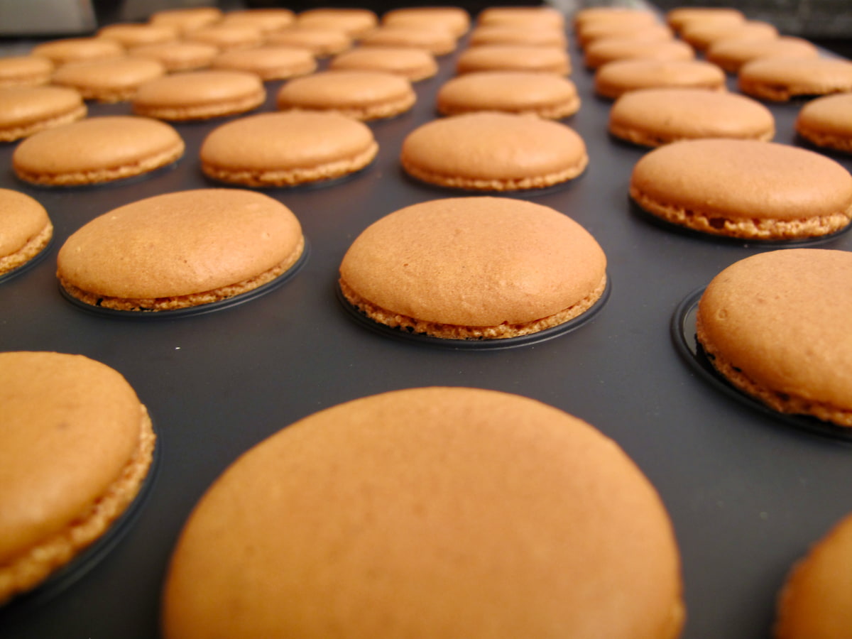 macarons baked on a silicone mat with very small feet