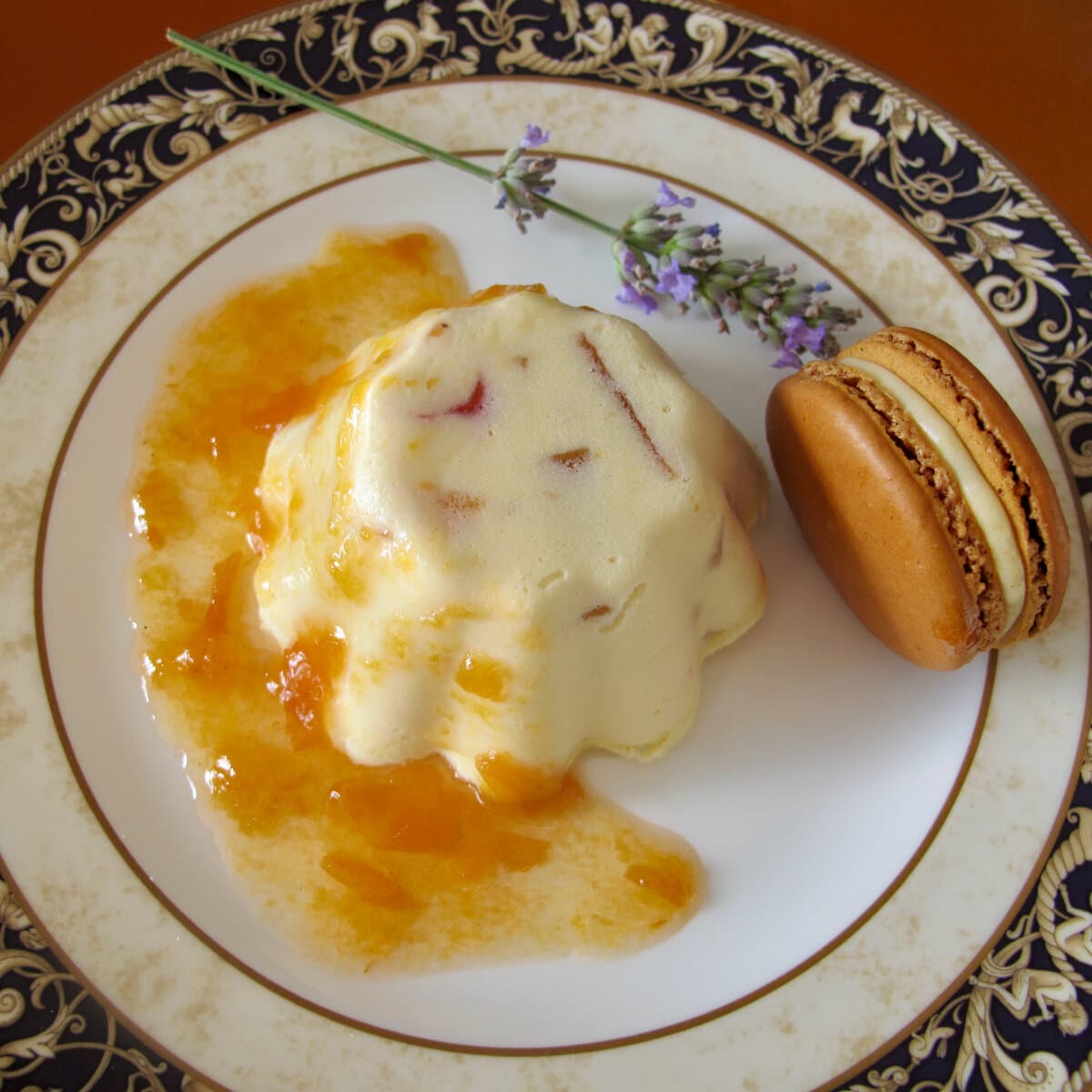 individual ice cream with candied fruits on plate with lavender, apricot sauce and a macaron
