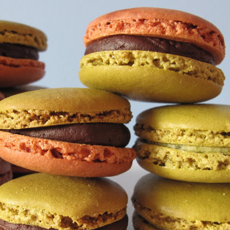 pistachio and chocolate macarons piled on top of one another