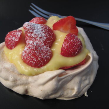 mini pavlova meringue nests filled with lemon cream topped with strawberries