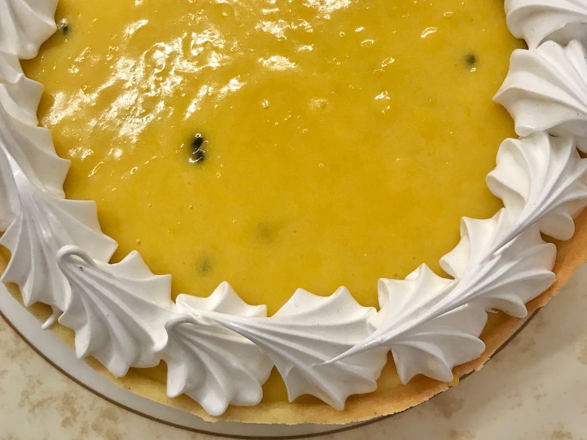 shiny lemon tart with meringue piped around the border