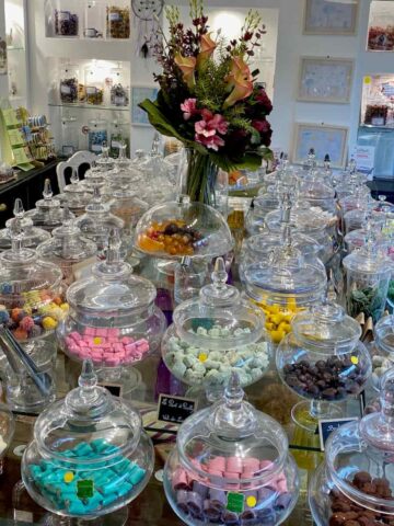 table groaning with hundreds of glass jars filled with sweets and candies