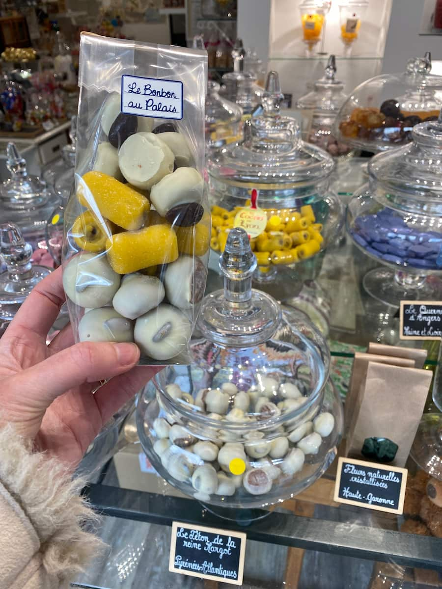 holding a bag of French candies in a specialised sweet shop in Paris