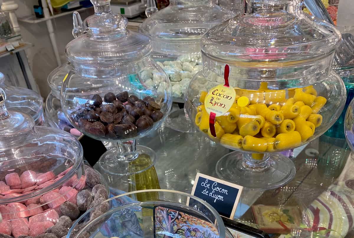 glass jars containing various candies including bright yellow marzipan sweets