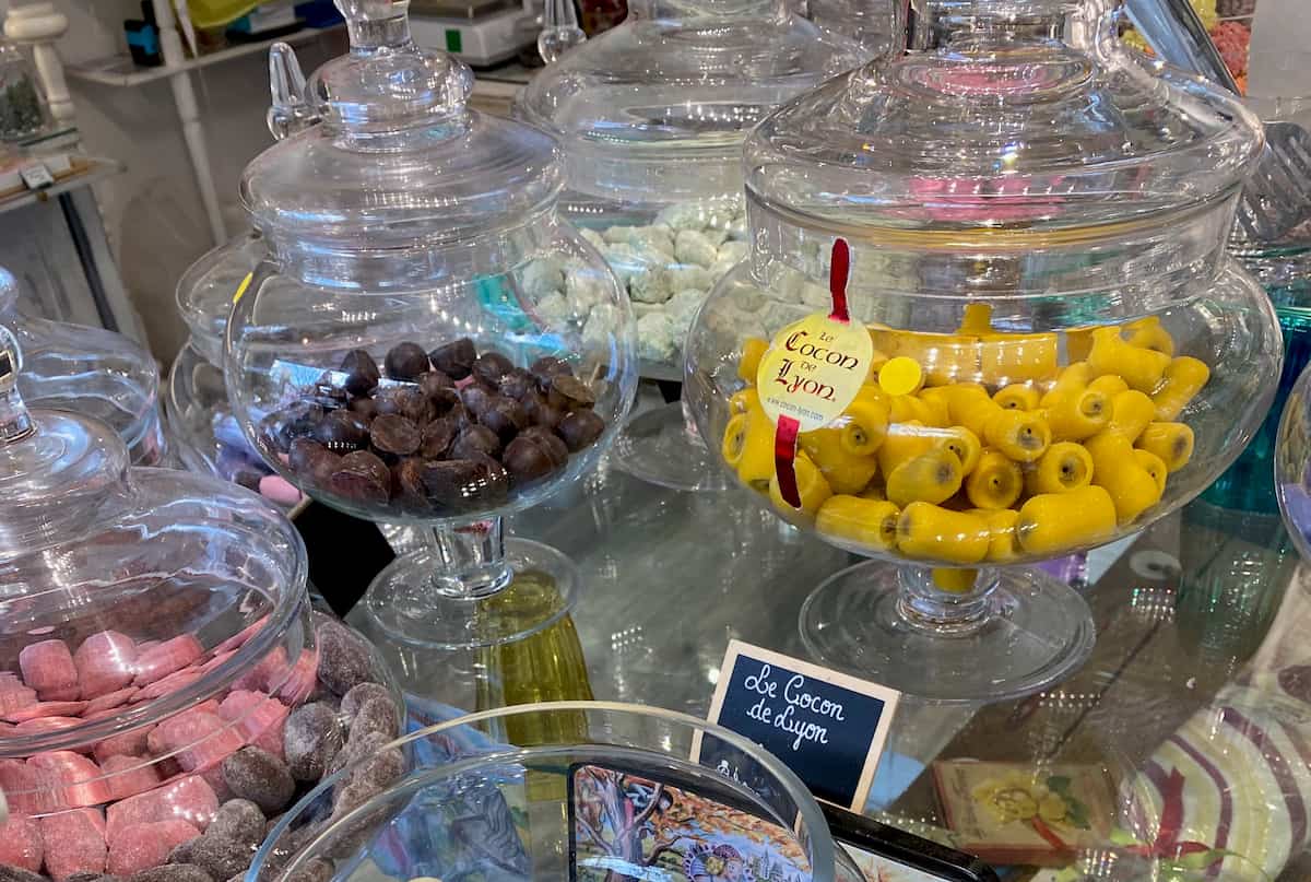 apothecary jars of traditional French sweets glass jars containing various candies including bright yellow marzipan sweets