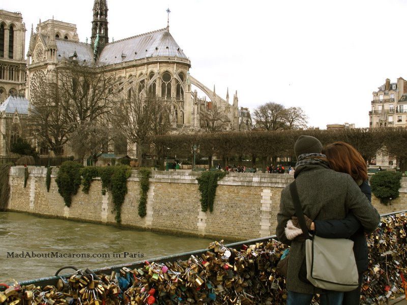 Romantic couple on the love lock bridge near Notre Dame in Paris