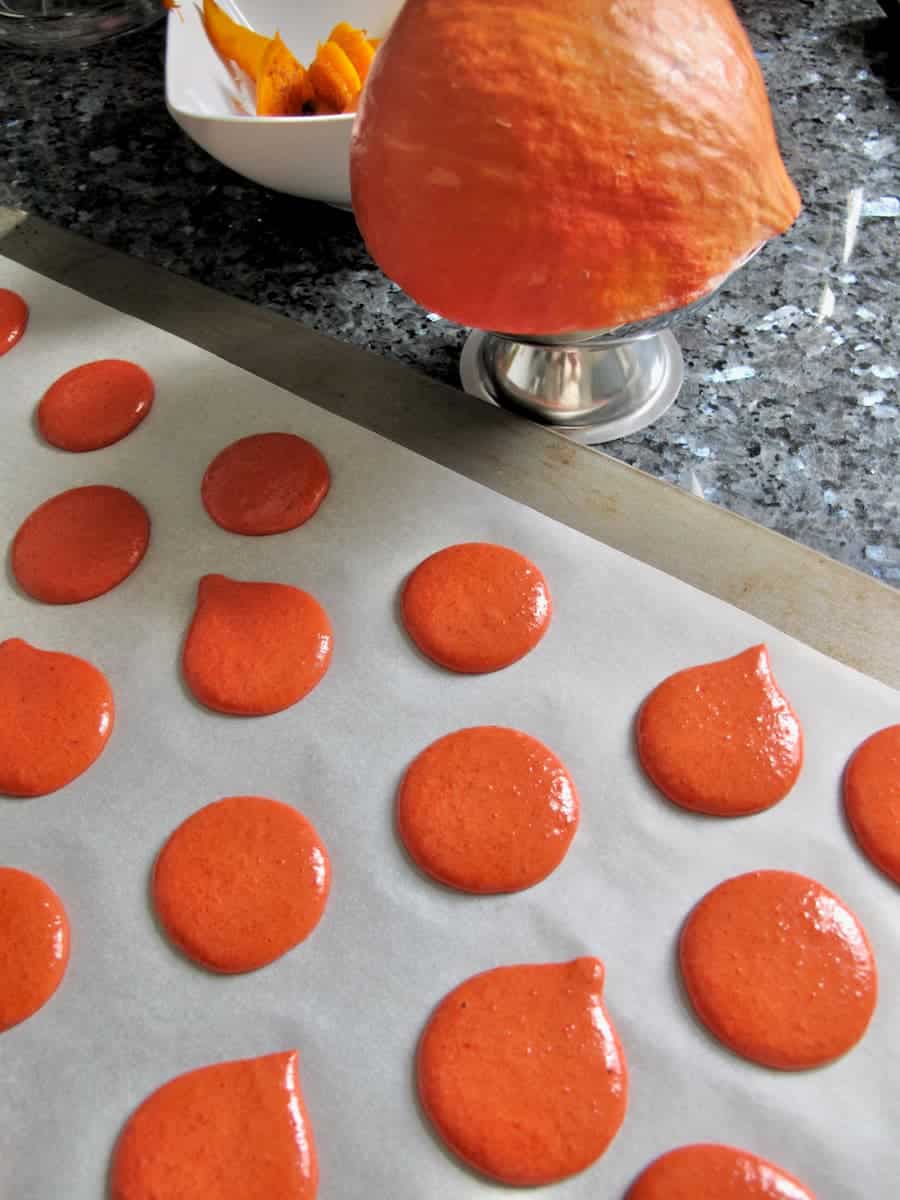 piped out orange pumpkin-coloured macarons