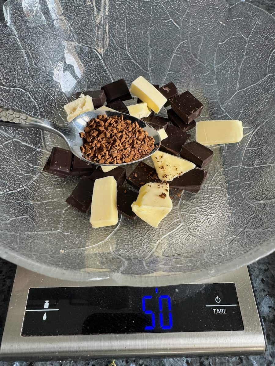 broken chocolate, butter chunks and coffee granules in a bowl