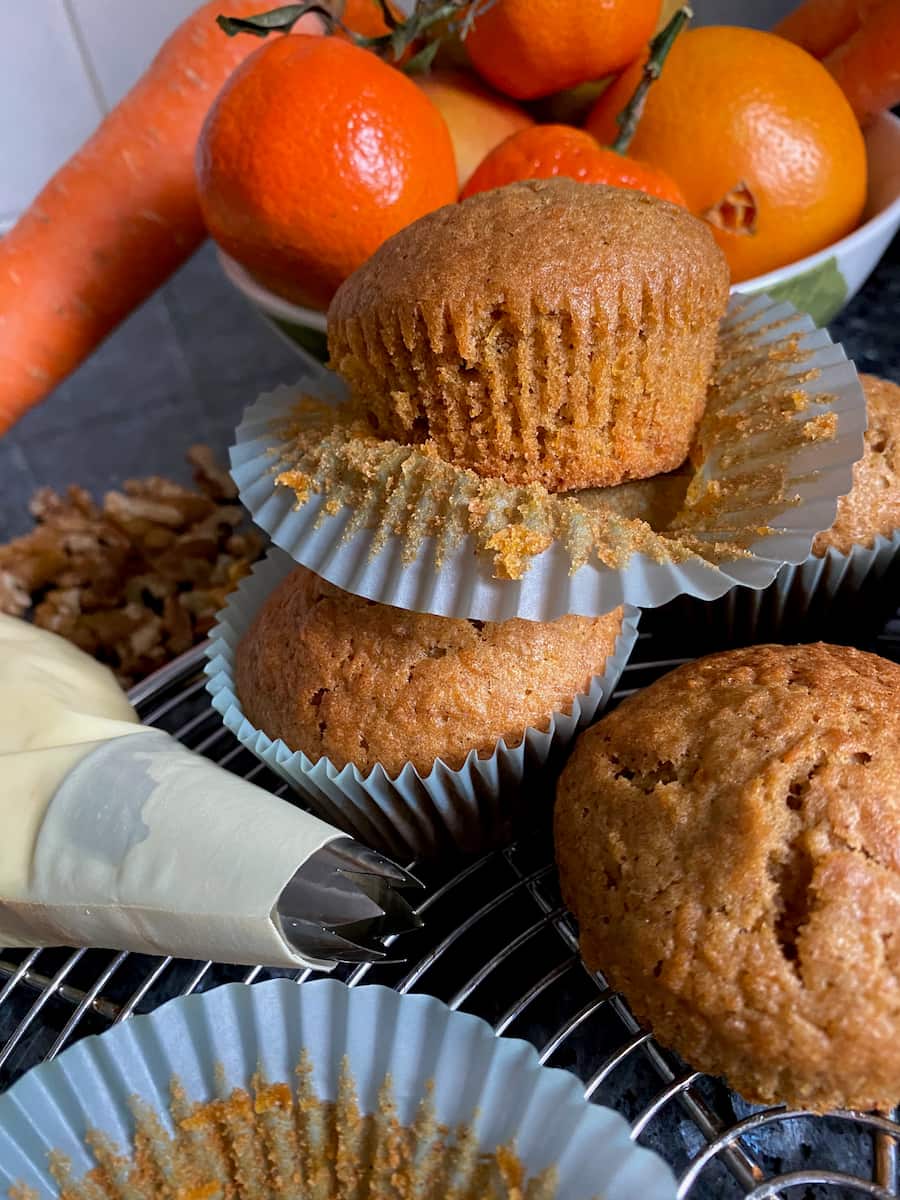 Taking muffins out of paper cases with carrot and oranges