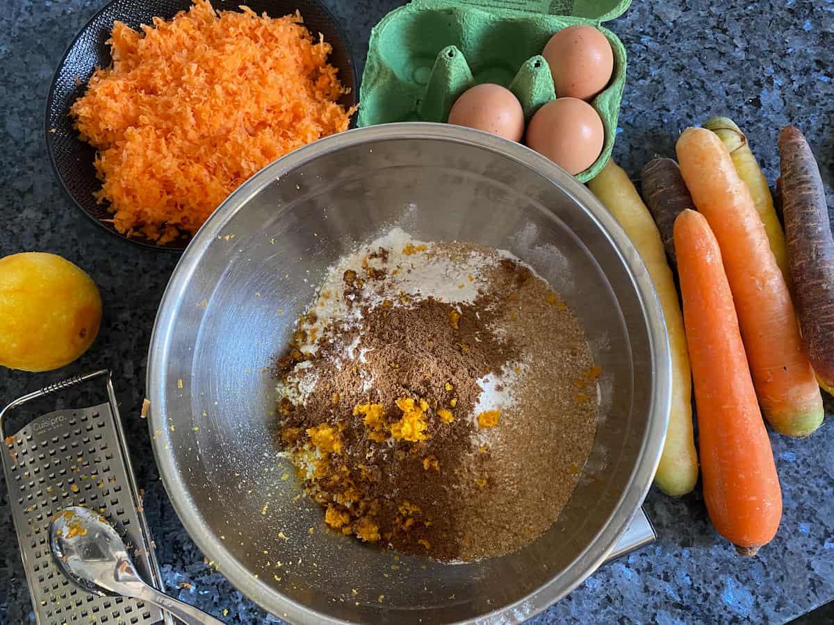 orange zest on spice, flour and other ingredients for carrot cake