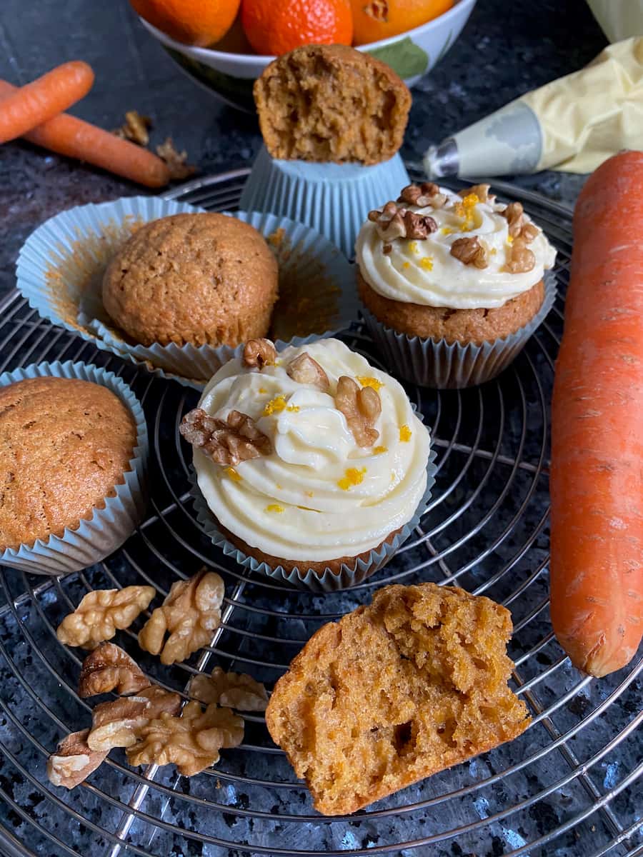 Making carrot cakes with frosting, orange zest and walnuts