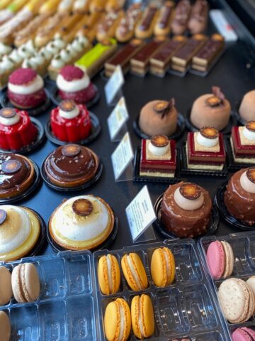 rows of French cakes and macarons in the window