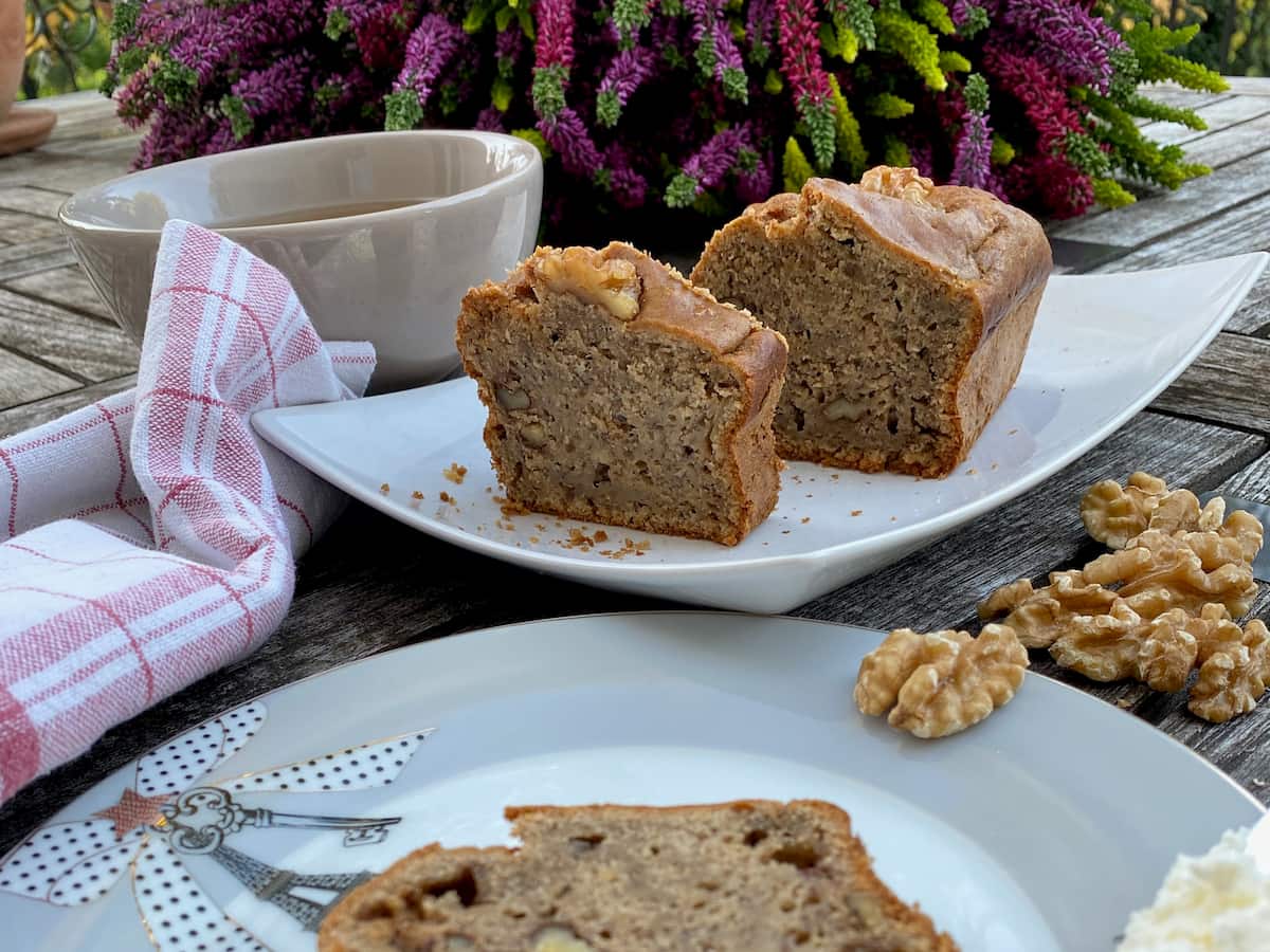 slices of banana cake with a bowl of coffee and walnuts