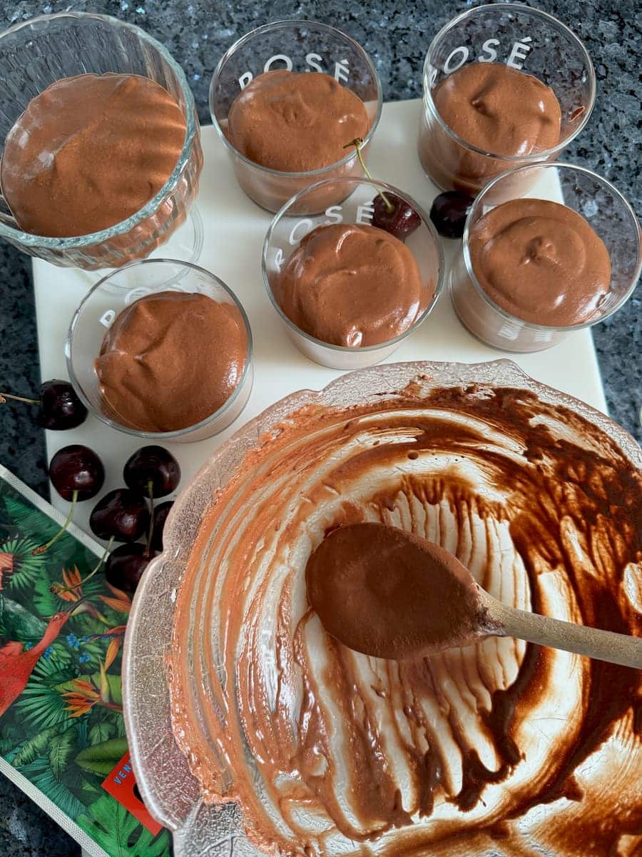 scraping a bowl of chocolate mousse to make small serving bowls