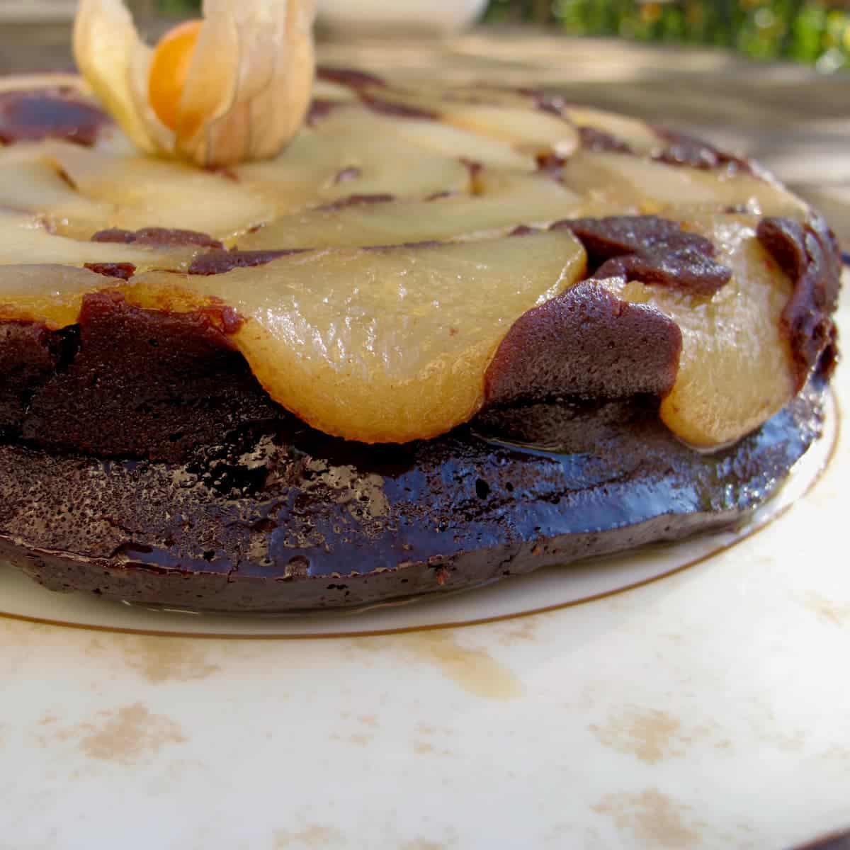close-up of pears falling over the edge of a dark chocolate cake