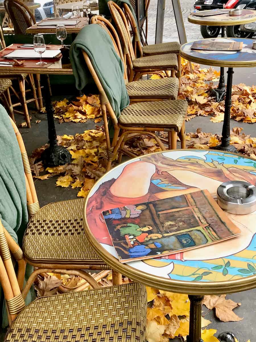 French café tables surrounded with fall leaves in Montmartre