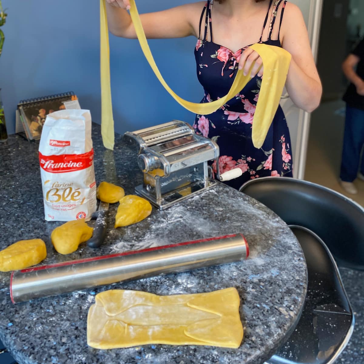 stretching out pasta dough to make fresh egg noodles