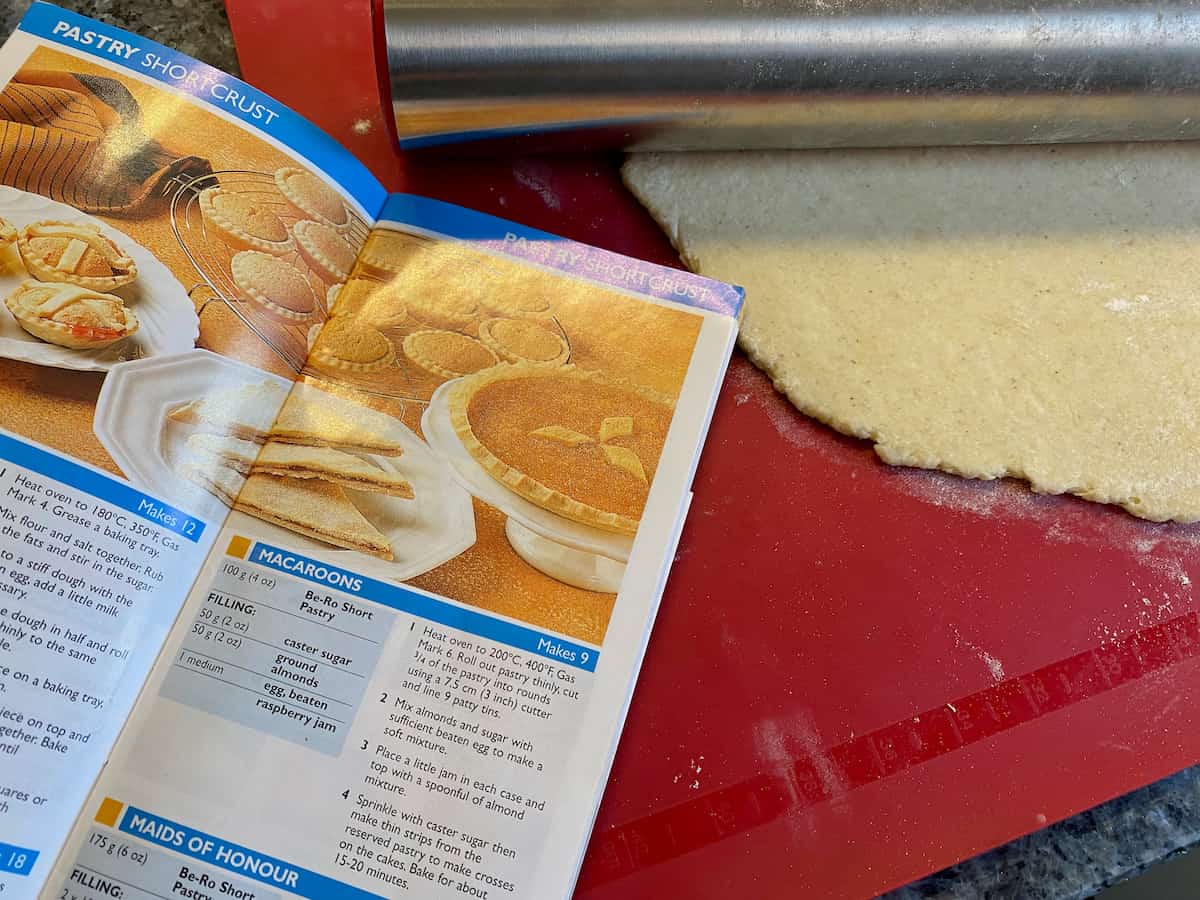 open recipe book for British macaroons as rolling pastry for them