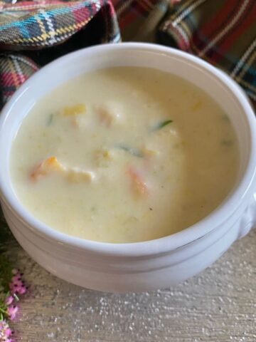 white lion bowl of creamy fish soup surrounded by tartan and heather
