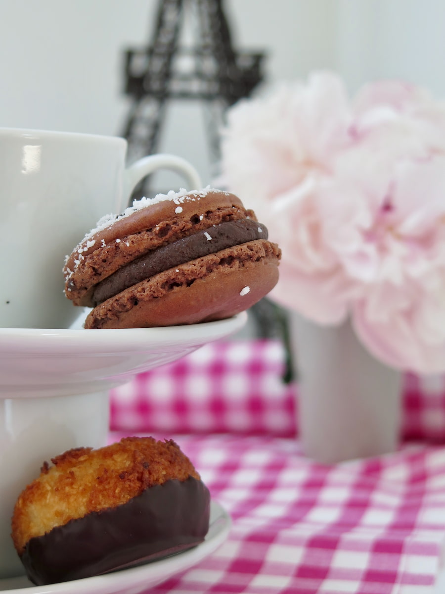 macaroons vs macarons - showing a chocolate macaron on a saucer with a coconut macaroon underneath
