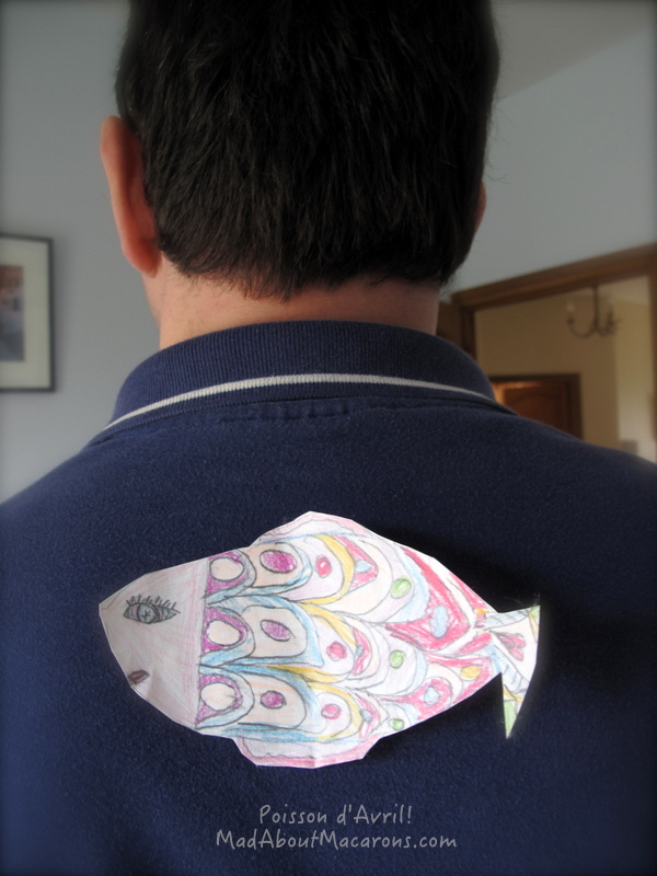 colourful paper fish stuck to someone's back