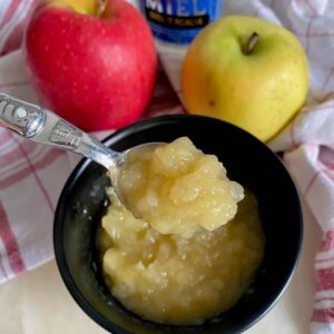 bowl of chunky apple compote, with a spoonful showing the specks of vanilla in it