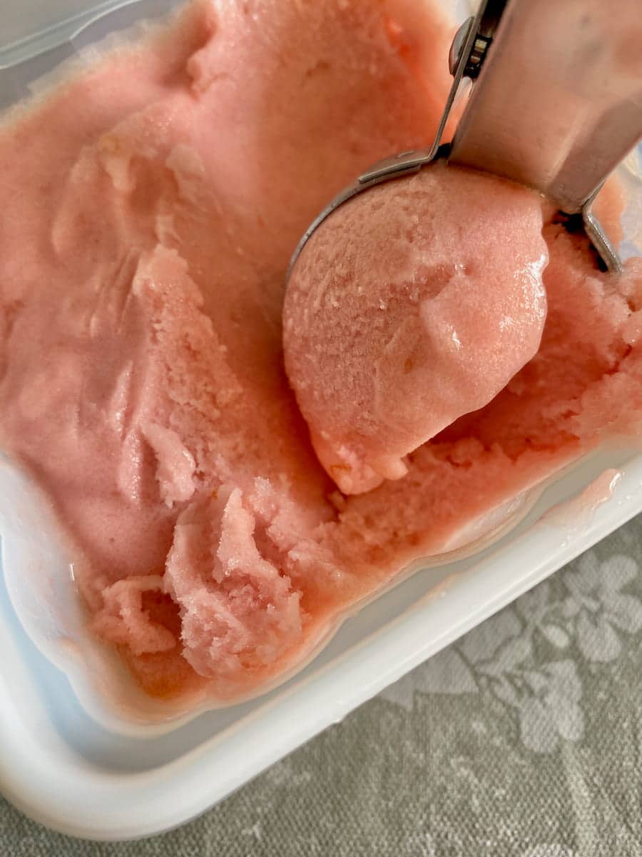 scooping out some soft yet firm pink fruit sorbet