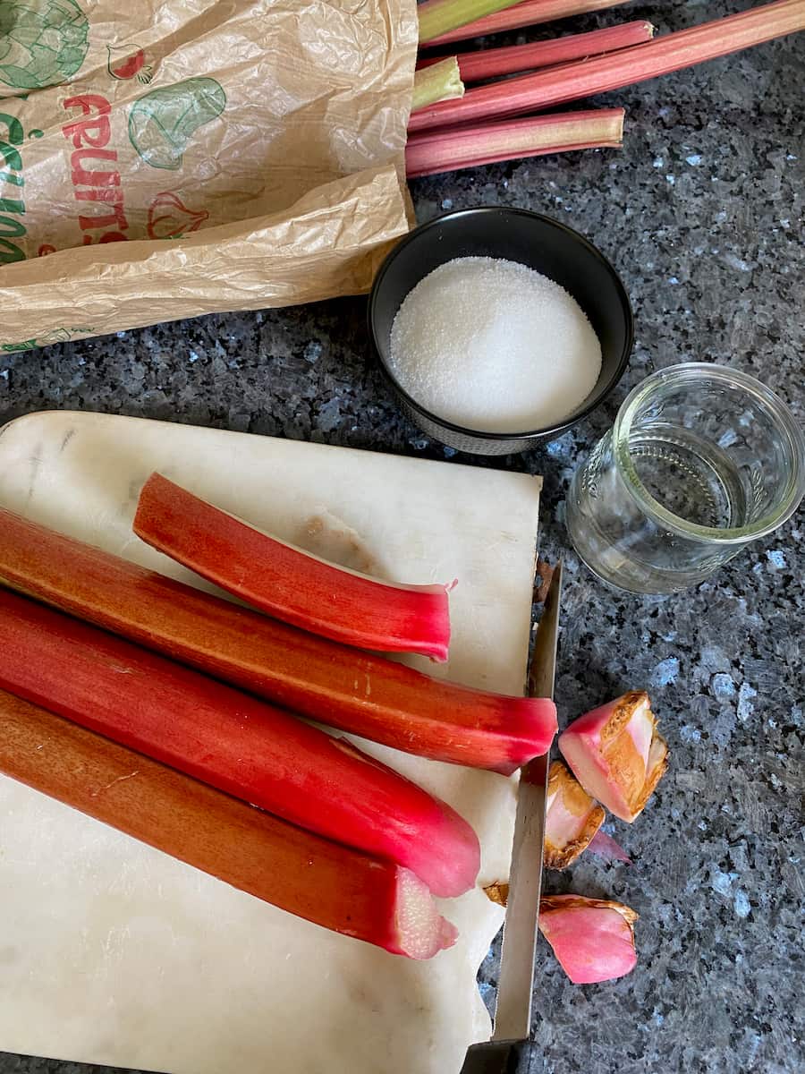 cutting rhubarb sticks with bowls of sugar and water