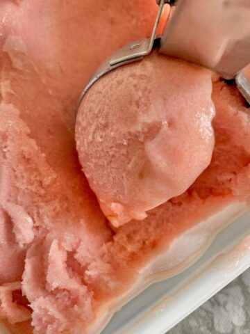 ice cream scoop of pink sorbet in a tub