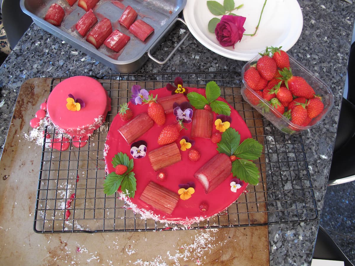 red glazed tart with strawberries and flowers on baking rack