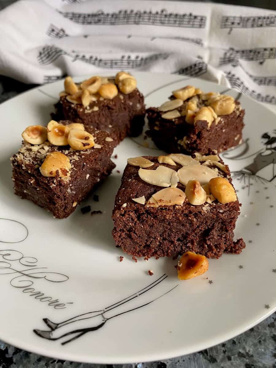 squares of lush dark chocolate brownies topped with toasted nuts