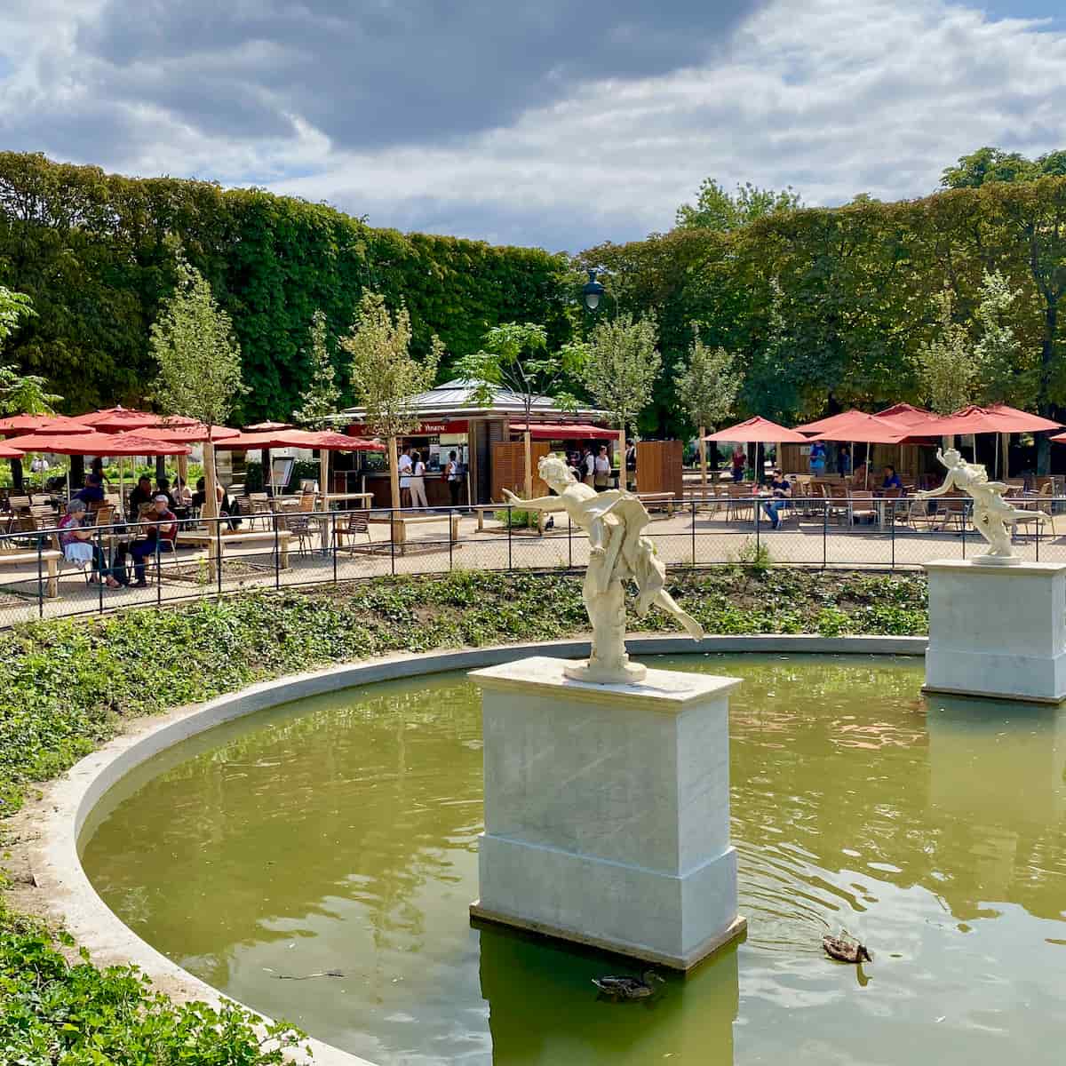 outside restaurant looking on to marble statues in a basin with ducks