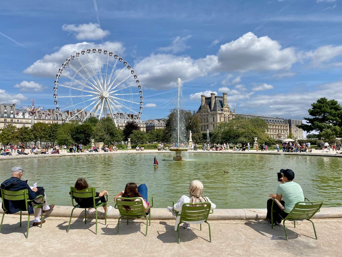 People sitting in chairs around the main fountain in Paris's Tuileries garden