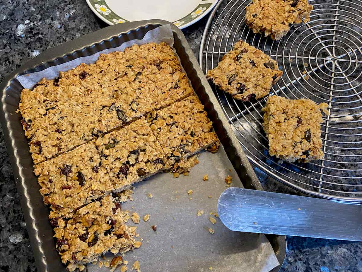cutting oat flapjacks in the tin and transferring to a wire tray